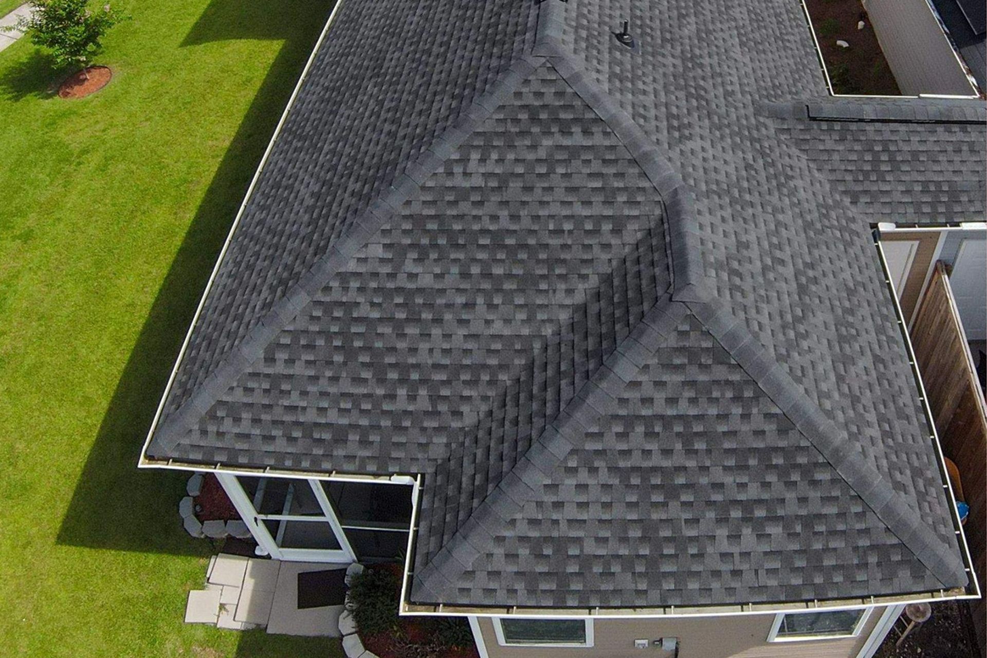 An aerial view of a house with a black roof.