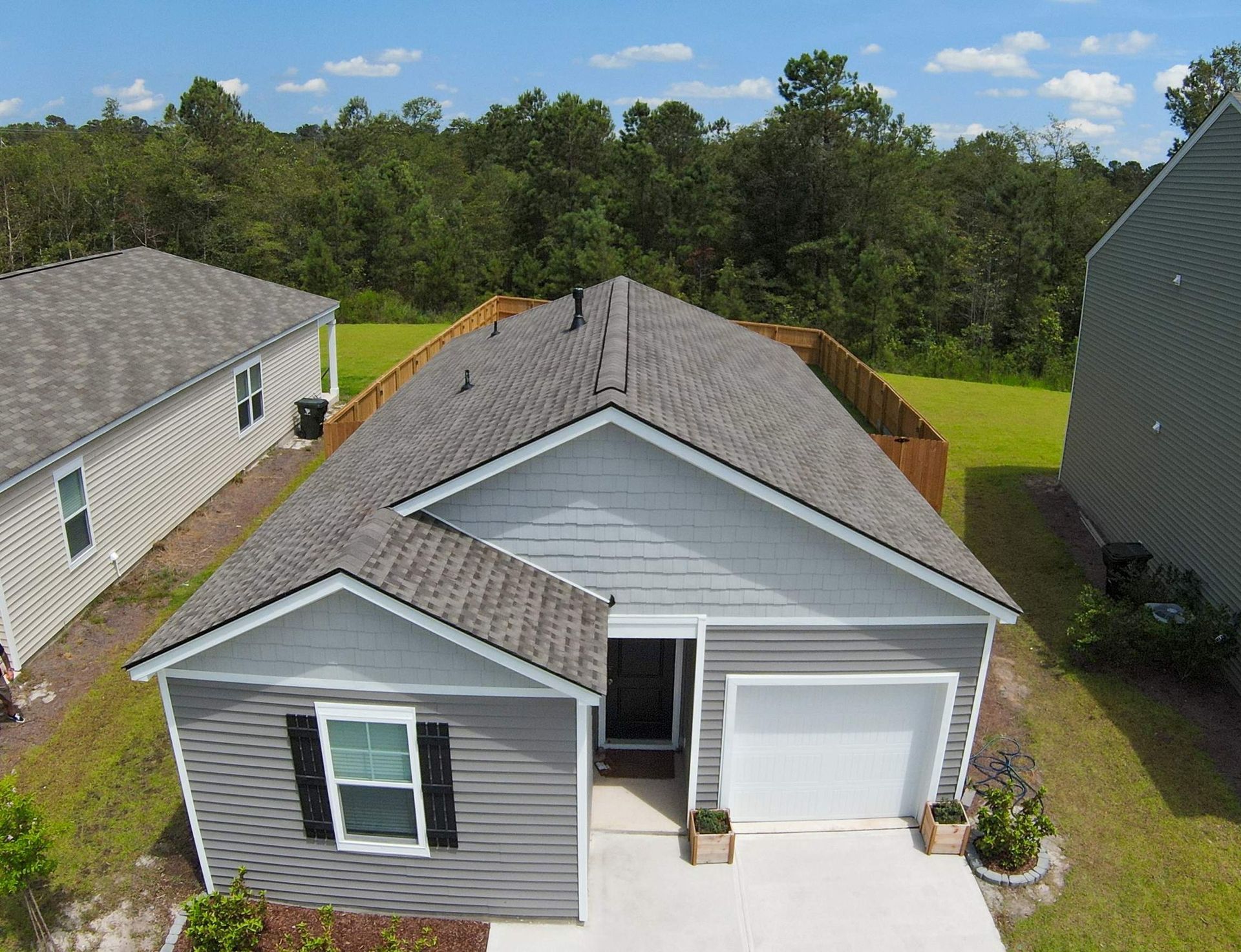 An aerial view of a small house with a gray roof