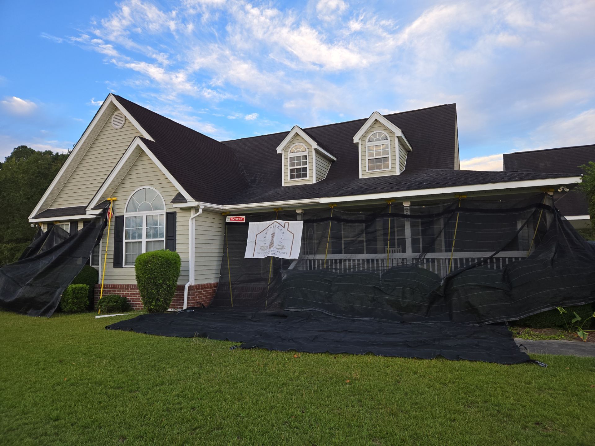 A house with a black tarp on the front of it