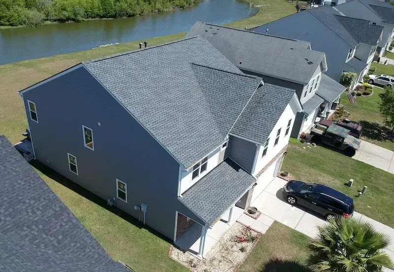 An Aerial View Of A Row Of Houses With A Lake In The Background — Summerville, SC — Palm & Pineapple Roofing and Exteriors
