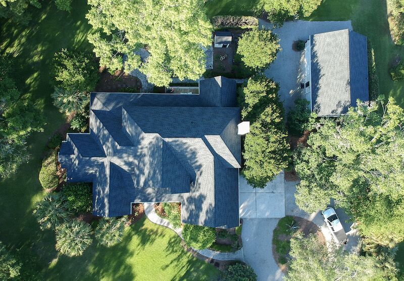 An Aerial View Of A House Surrounded By Trees — Summerville, SC — Palm & Pineapple Roofing and Exteriors
