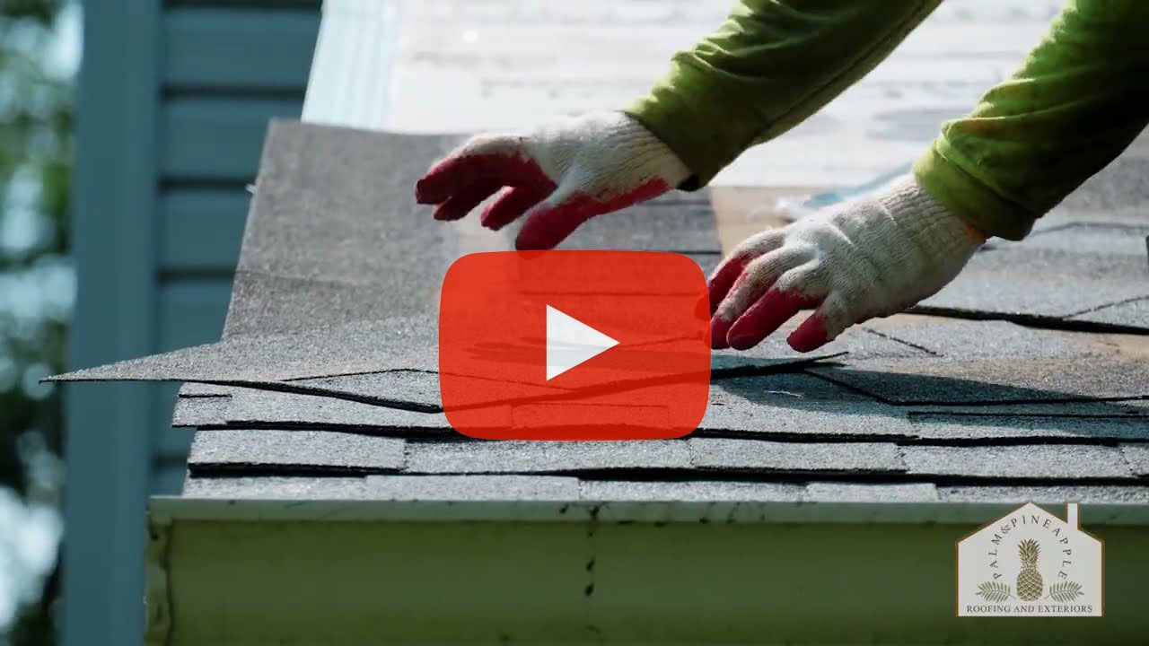 Person on roof placing shingle over a gutter. Gray shingles with an overlayed YouTube play button.