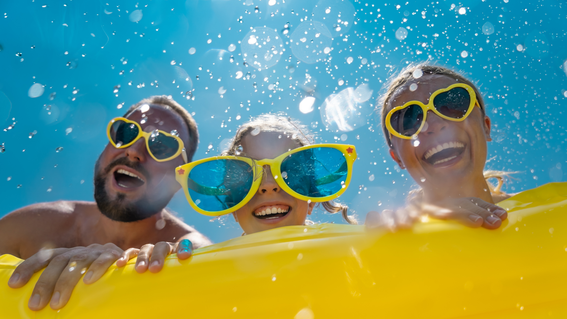 A group of people wearing sunglasses are playing in the water.
