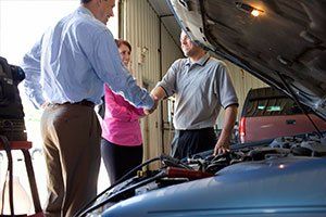 Couple shaking hands with auto mechanic - Trans Doc Transmissions in Post Falls, ID