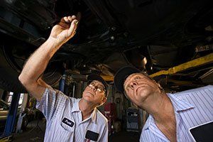 Mechanics looking up under car on lift - Trans Doc Transmissions in Post Falls, ID Mechanics looking up under car on lift - Trans Doc Transmissions in Post Falls, ID