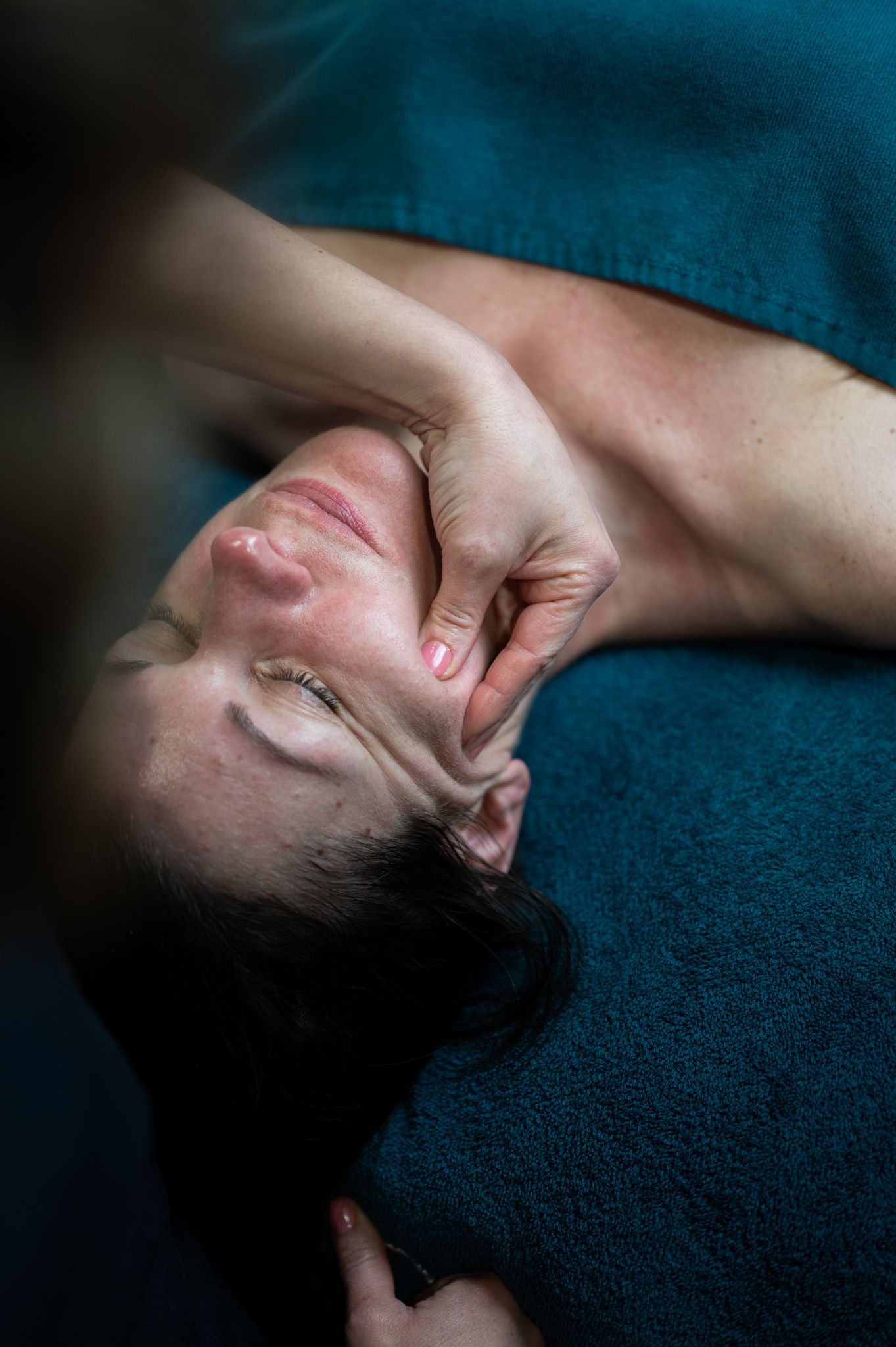 Une femme reçoit un massage du visage dans un spa.