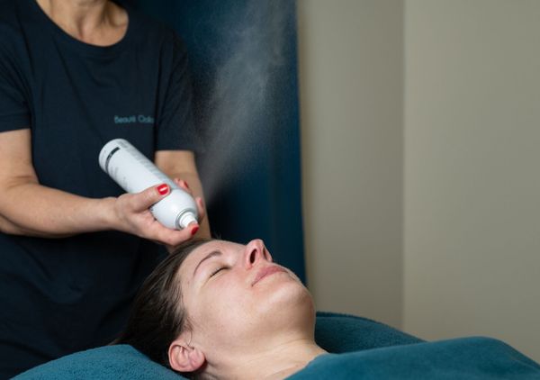 Une femme se fait vaporiser le visage dans un spa.