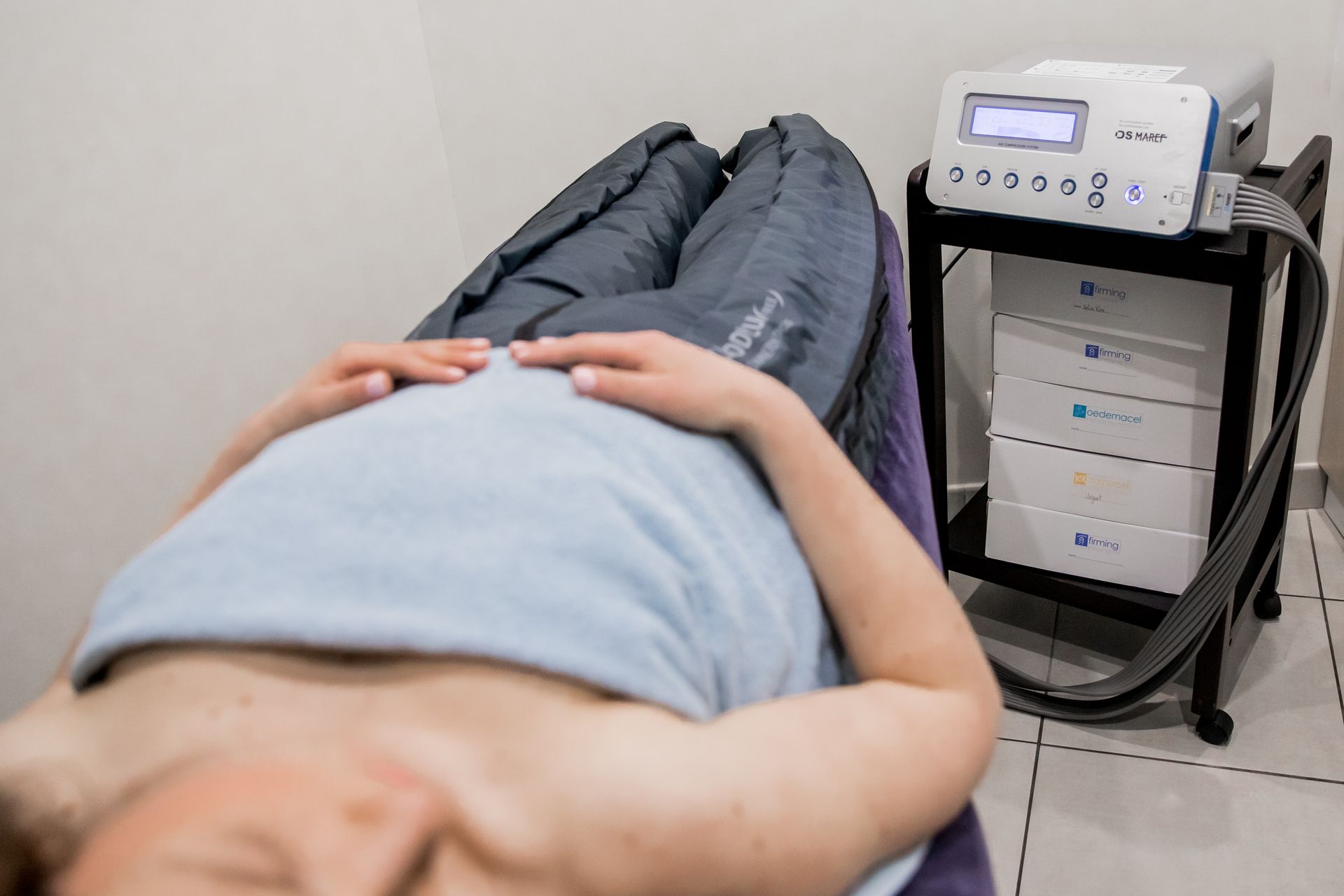 Une femme est allongée sur un lit avec une machine en arrière-plan.