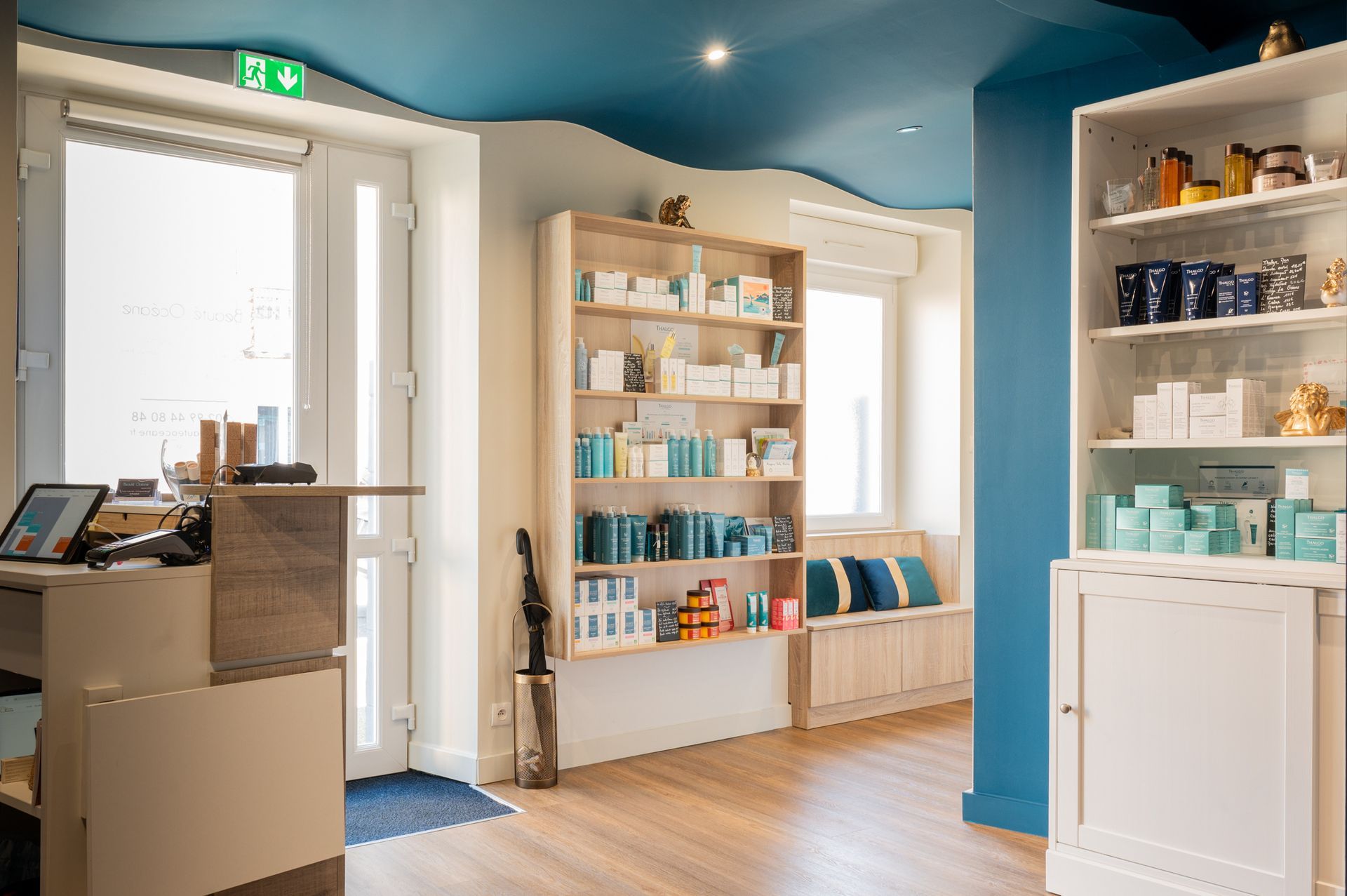 Une pièce avec un plafond bleu, un comptoir, des étagères et une fenêtre.