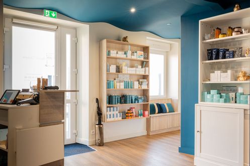 Une pièce avec un plafond bleu, un comptoir, des étagères et une fenêtre.
