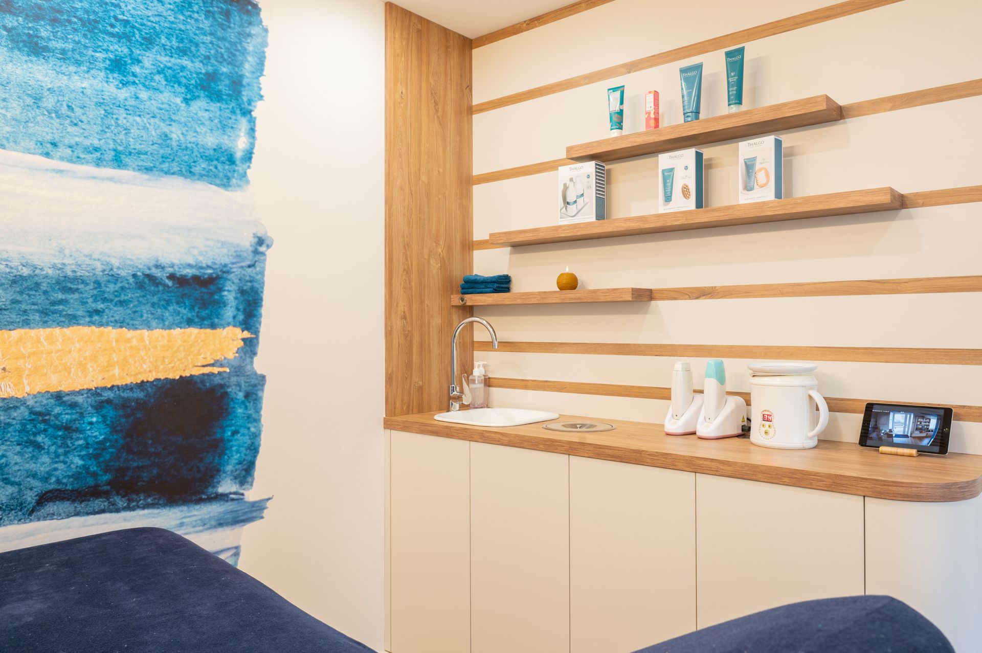 Une chambre avec un lit, des étagères, un lavabo et un tableau au mur.