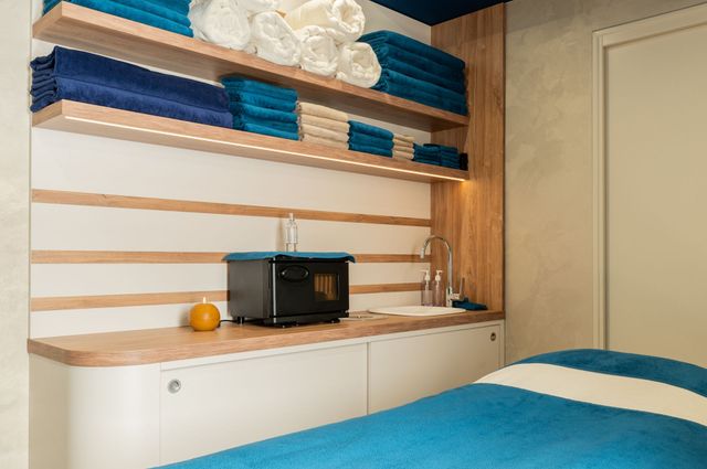 Une chambre avec un lit, des étagères, un lavabo et un micro-onde.