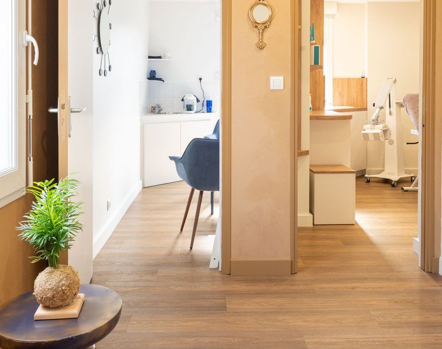 Une pièce avec une horloge au mur et une table avec une plante dessus