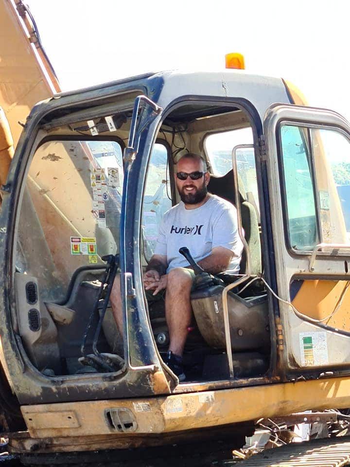 A Man is Sitting in the Driver 's Seat of an Excavator — Hastings Scrap Metal Recyclers in Wauchope, NSW