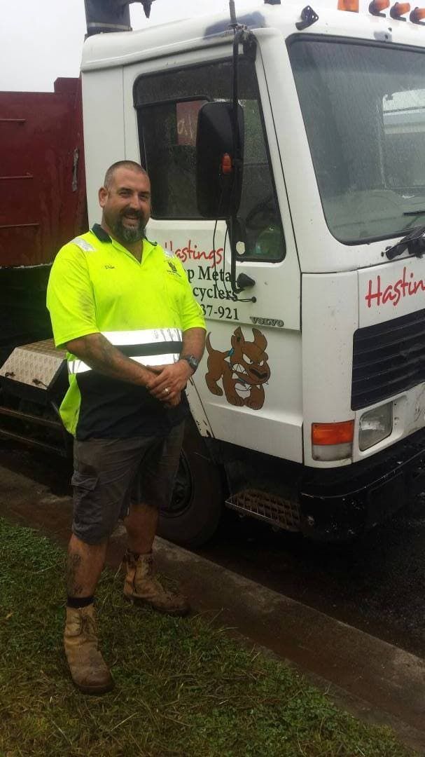 A Man in a Yellow Shirt is Standing in Front of a White Truck — Hastings Scrap Metal Recyclers in Bonny Hills, NSW
