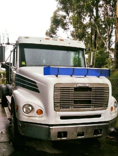A White Freightliner Truck is Parked in Front of a Fence — Hastings Scrap Metal Recyclers in Kew, NSW