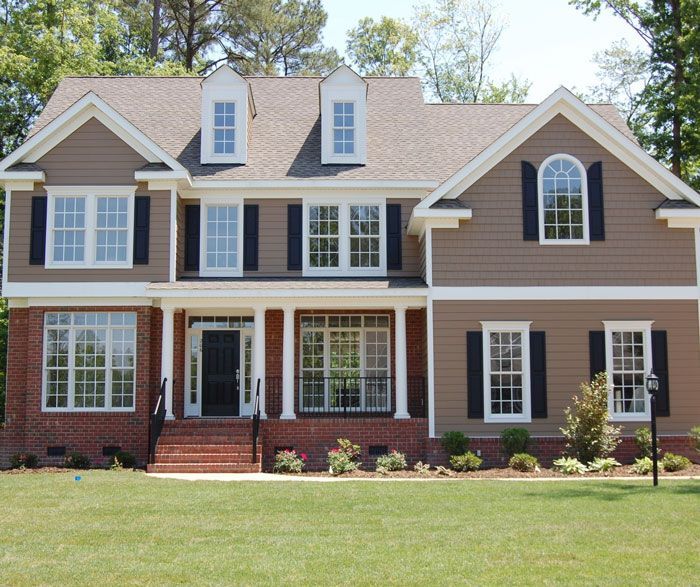 A large house with a lot of windows and black shutters