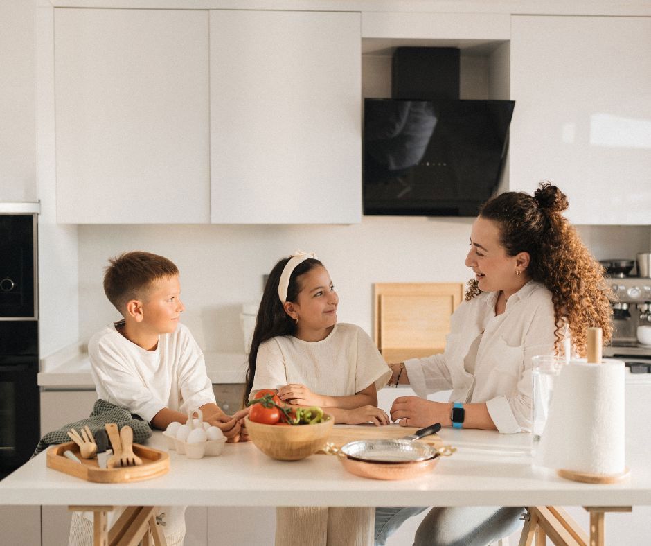 A woman and a little girl are playing in the kitchen.
