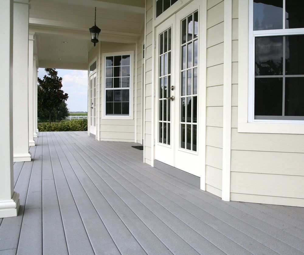 A white house with a gray porch and sliding glass doors