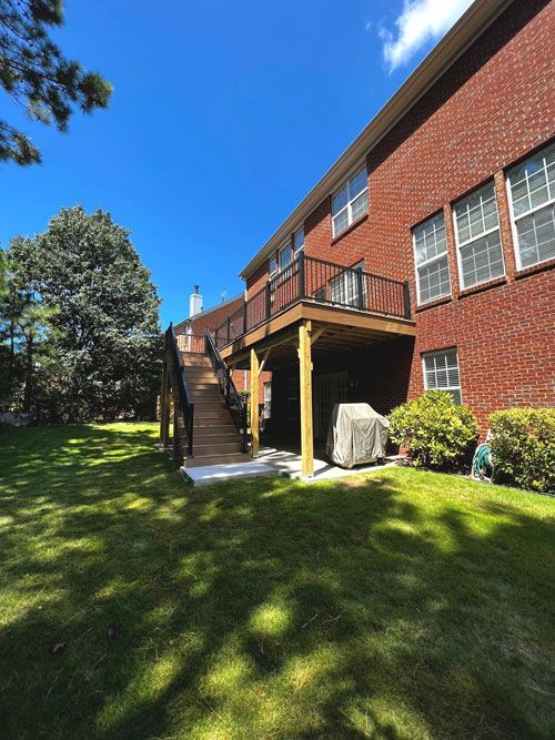 A brick house with a wooden deck and stairs