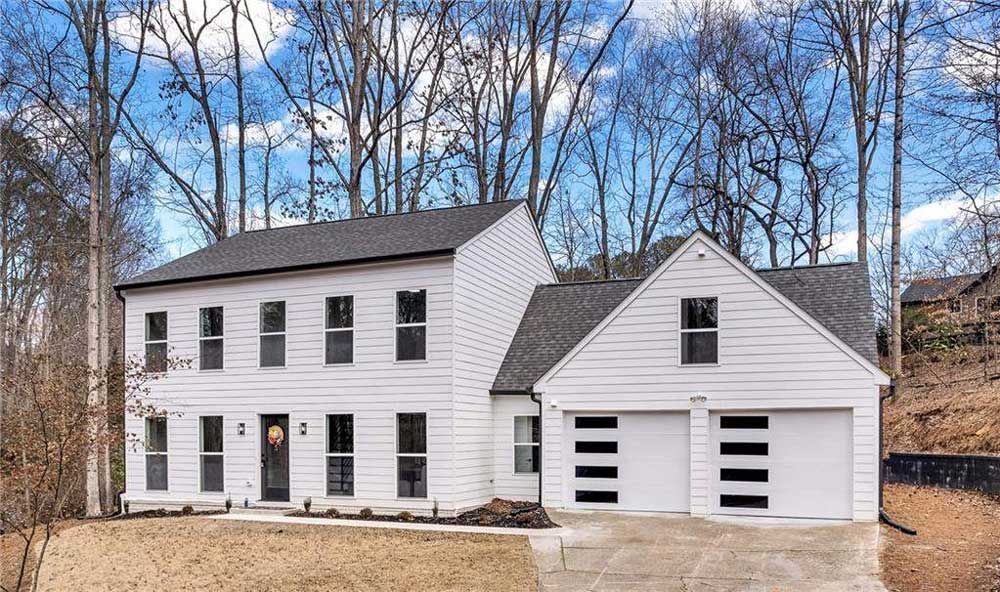 A large house with a large porch and a lot of windows.
