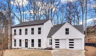 A large house with a large porch and a lot of windows.