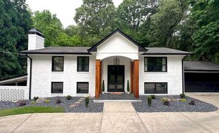 A white house with a yellow door and a gray roof