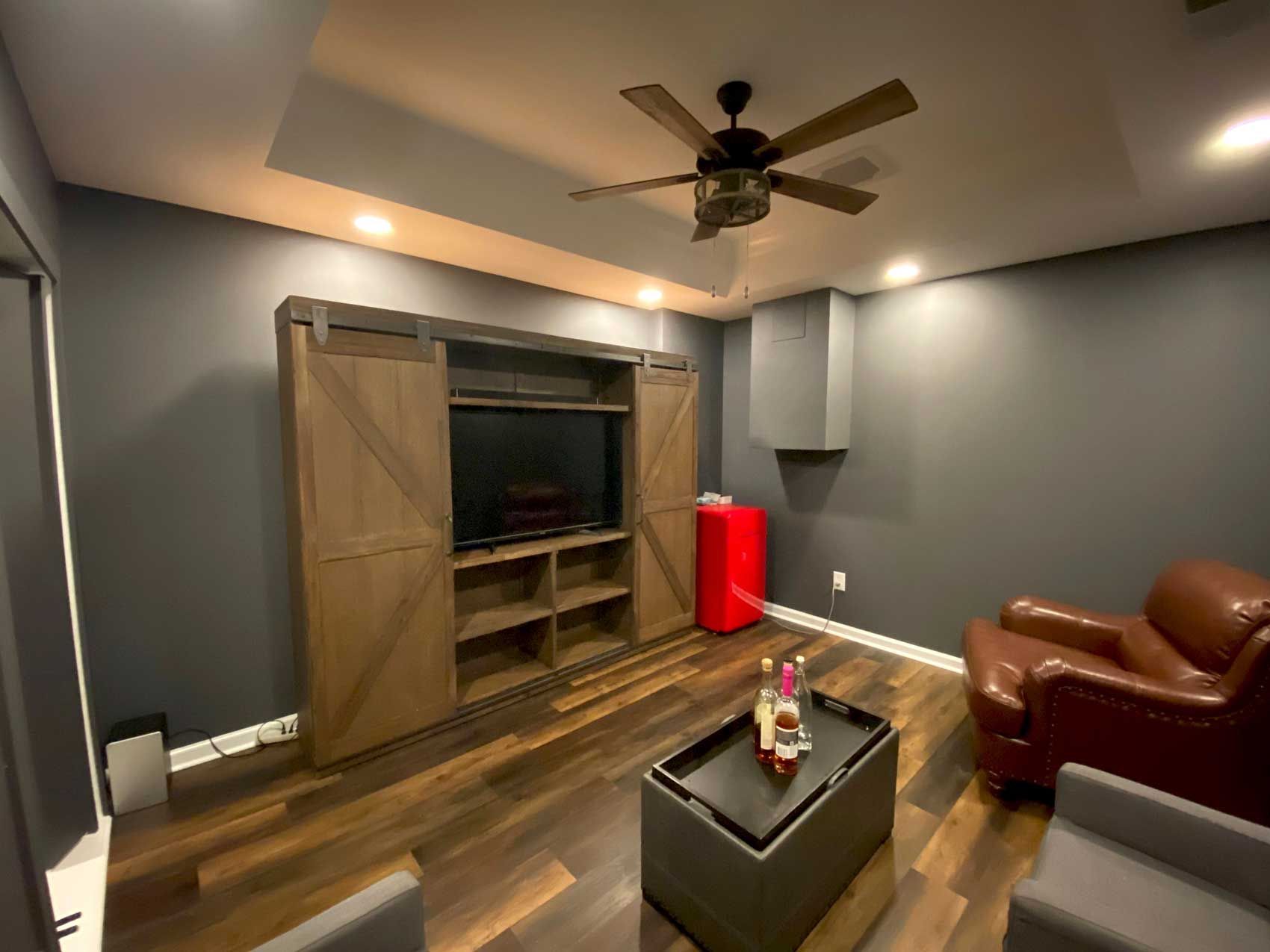 A basement with stairs and a flat screen tv