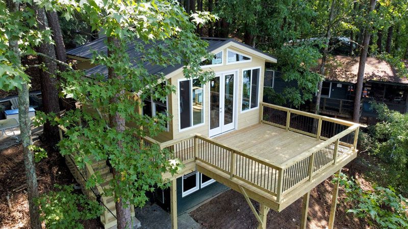 An aerial view of a tree house with a deck surrounded by trees.