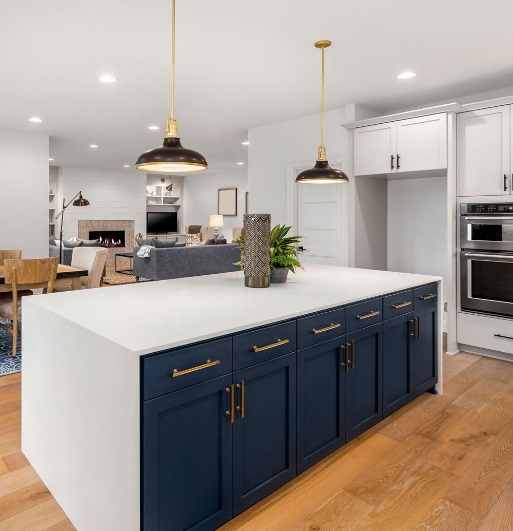 A kitchen with blue cabinets and a large island in the middle.