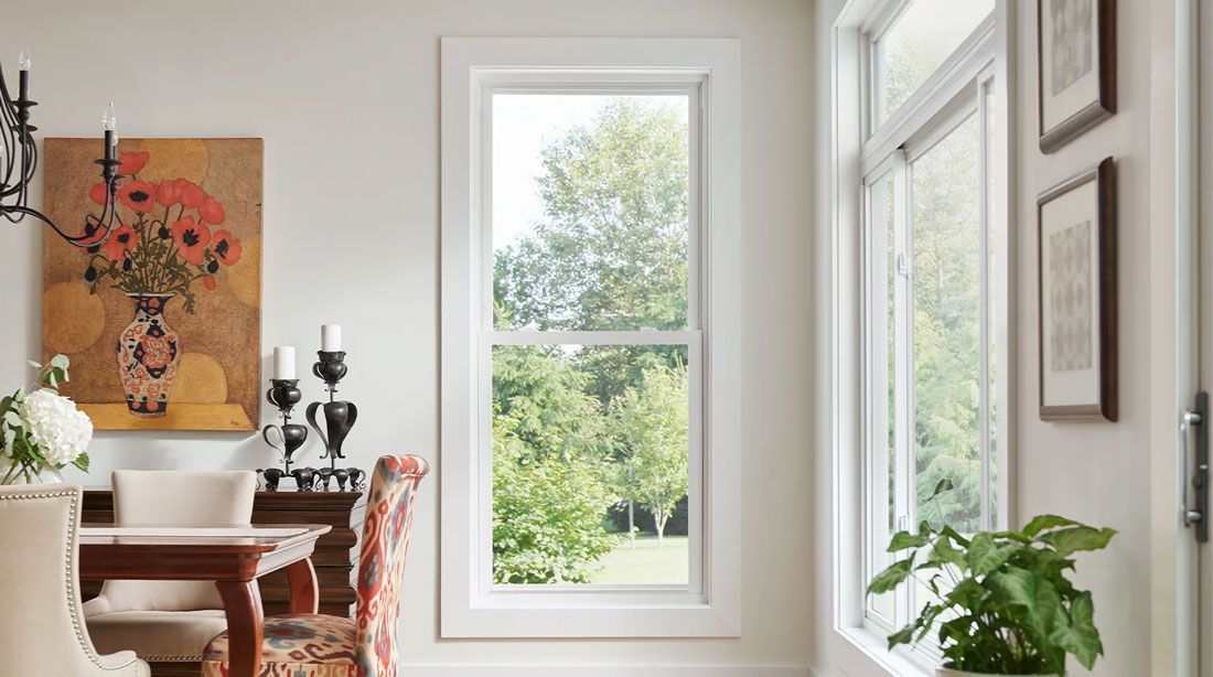 A dining room with a table and chairs and a large window.