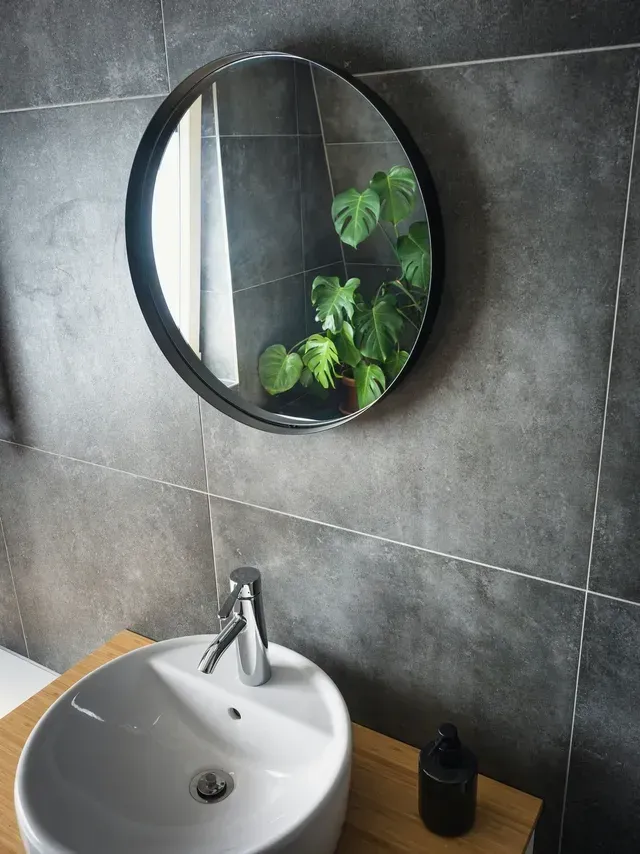 Round Mirror Over a White Sink in a Modern Bathroom — Cooloola Tile Company in Sunshine Coast, QLD