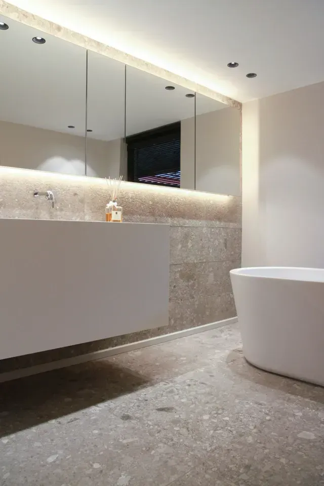 Modern Bathroom With Floating Sink, Large Mirror, Tub, and Stone Accent Wall — Cooloola Tile Company in Gympie, QLD