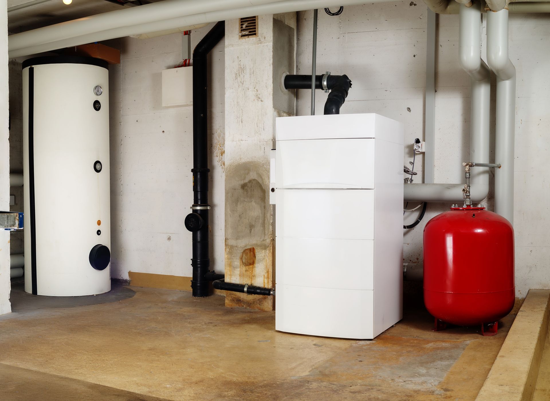 A room with a white refrigerator and a red tank