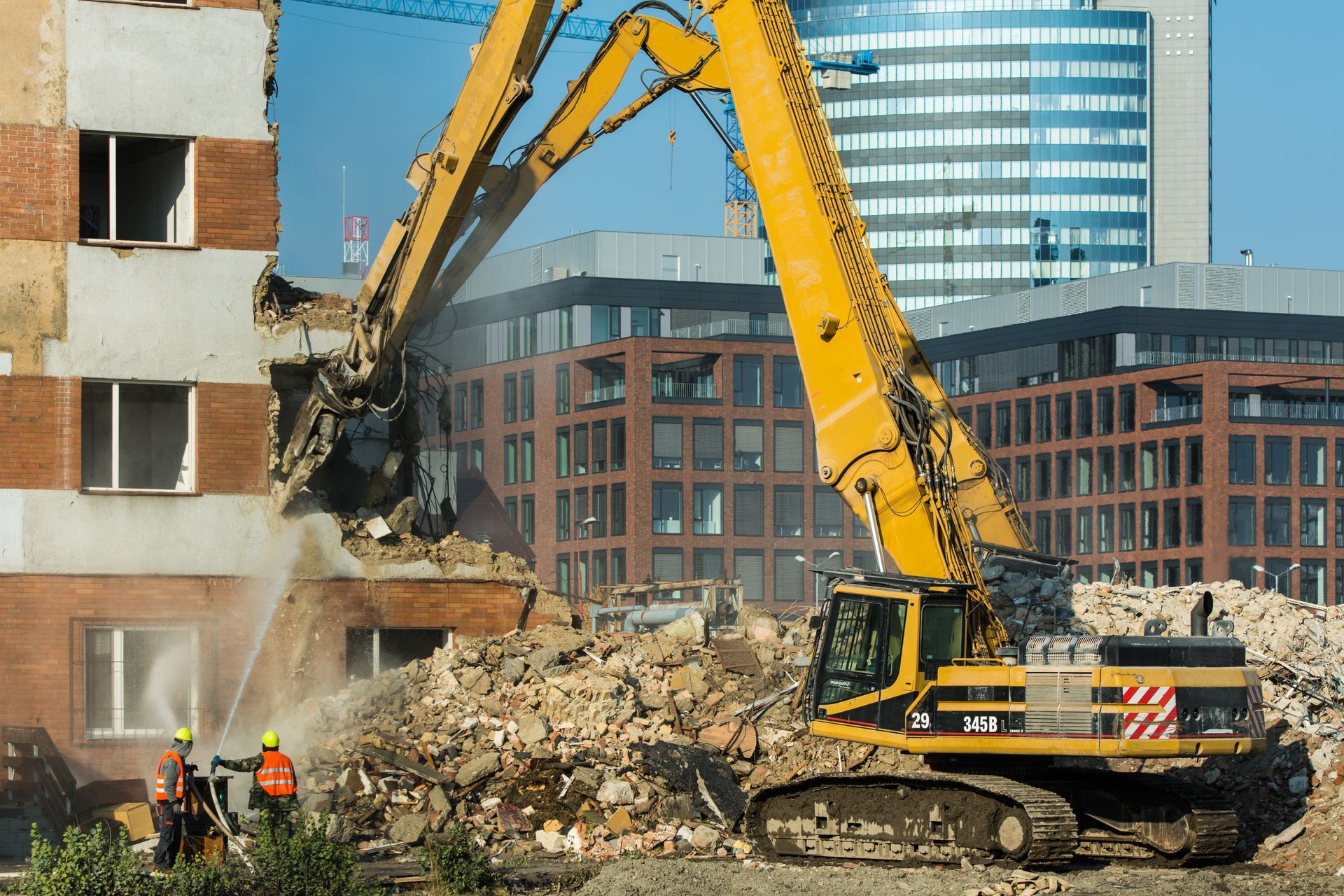 Demolition of an old building in the city's center with heavy equipment.