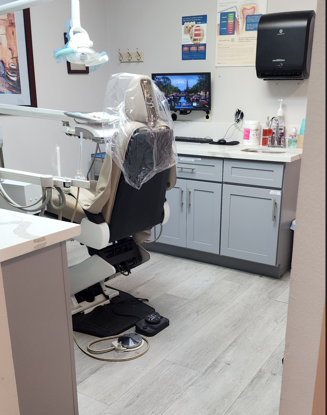 A dental office with a chair and a tv on the wall