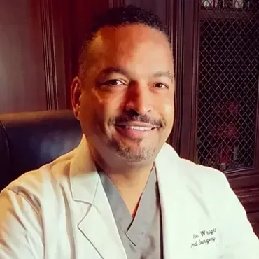 A man in a suit and tie is smiling for the camera