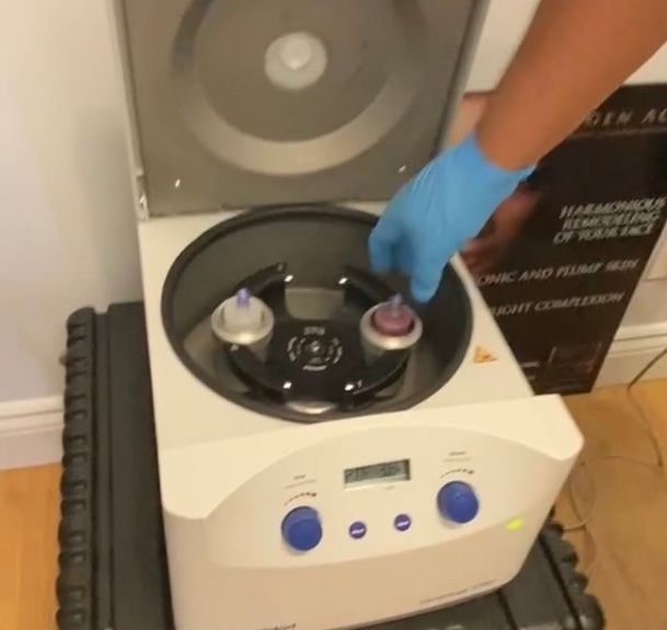 A person is using a centrifuge with a box behind it that says harmonics