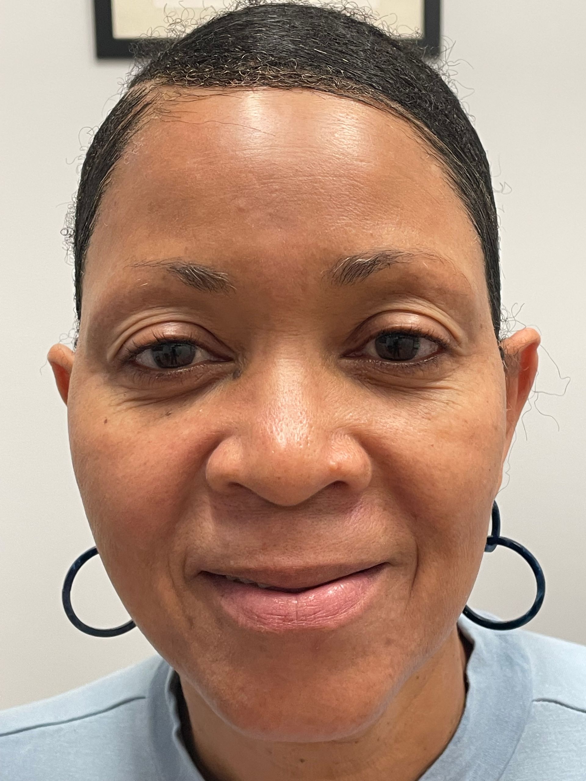 A close up of a woman 's face without makeup and earrings.