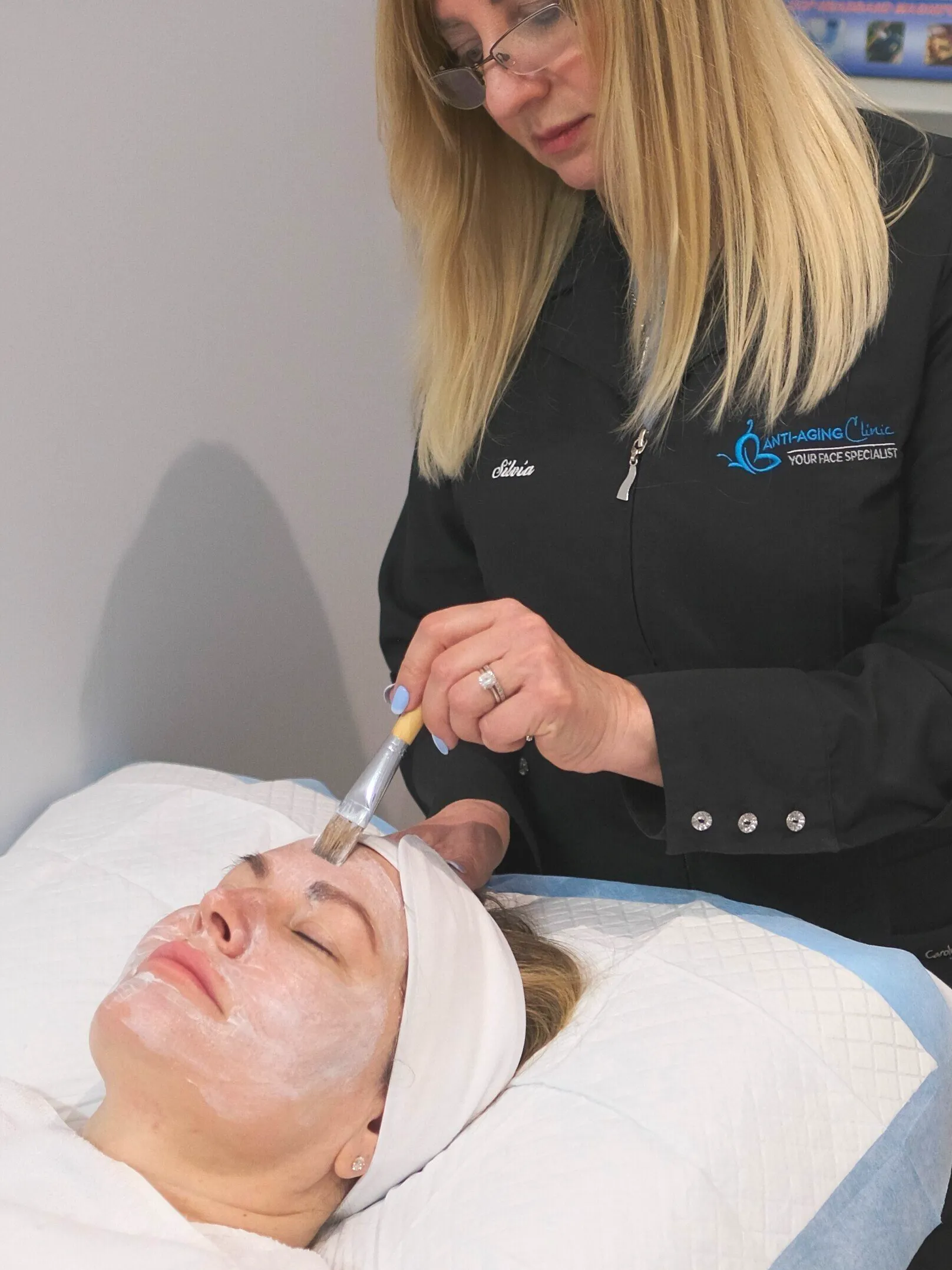 A woman is getting a facial treatment at a beauty salon.
