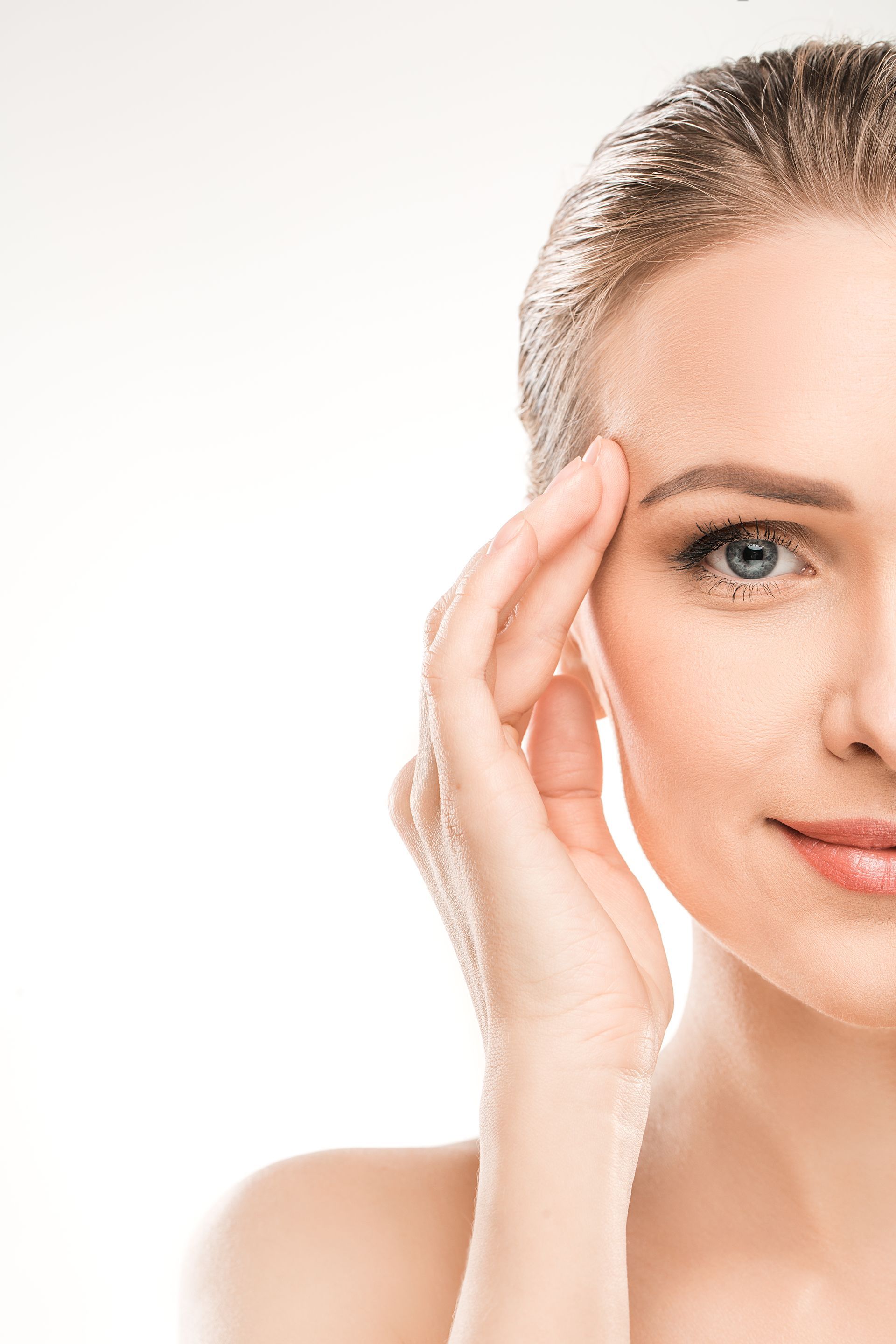 A woman is touching her forehead with her hand.