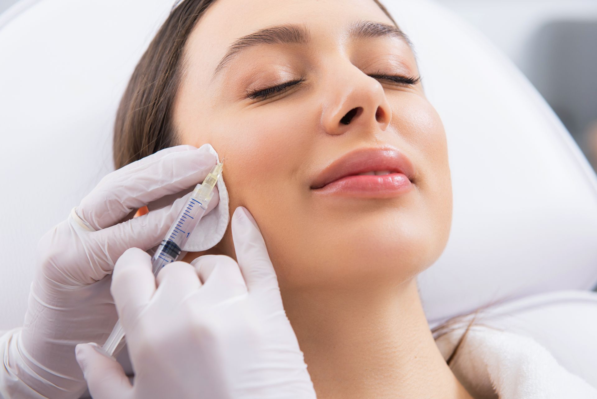 A woman is getting a botox injection in her face.