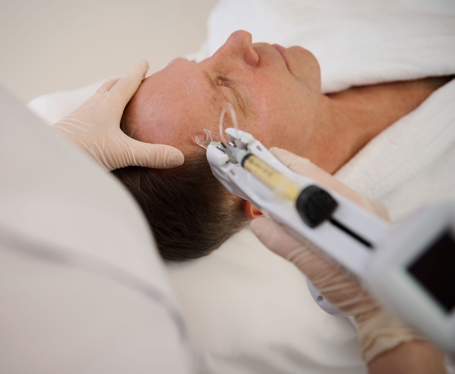 A man is getting a facial treatment with a syringe