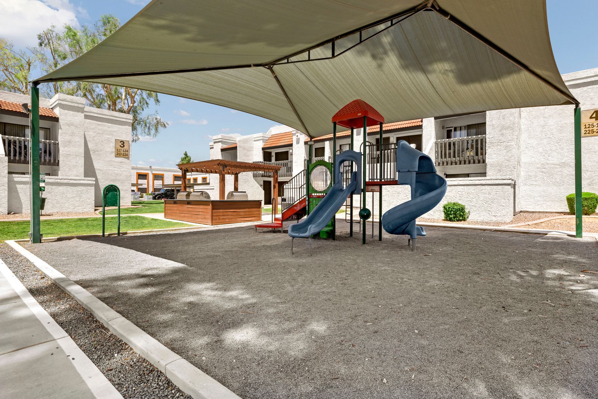 A white apartment building with a lush green lawn in front of it at Solei on West Thomas in Phoenix, AZ.