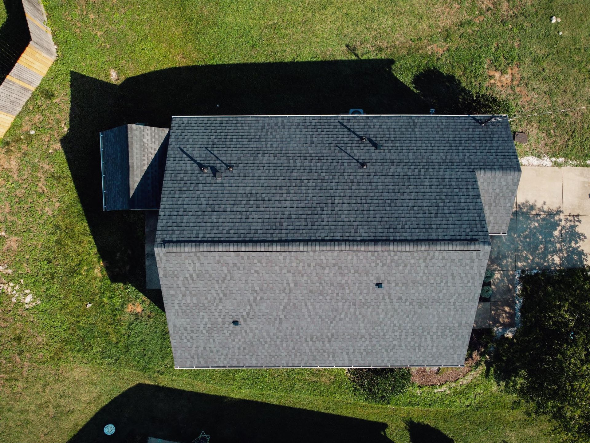 An aerial view of a house with a roof that is covered in shingles.