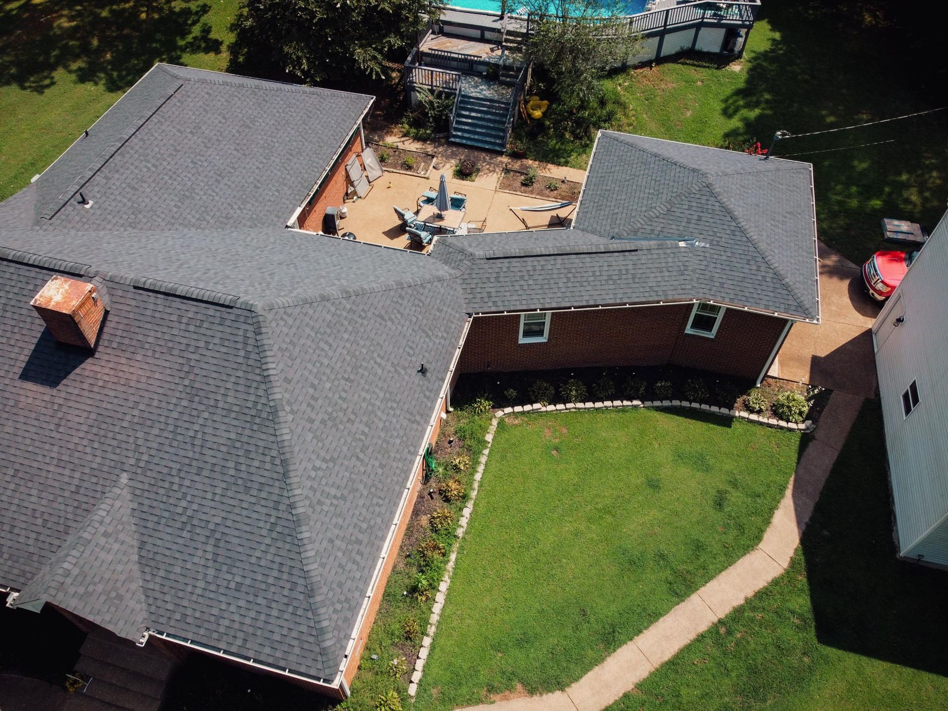 An aerial view of a house with a pool in the background