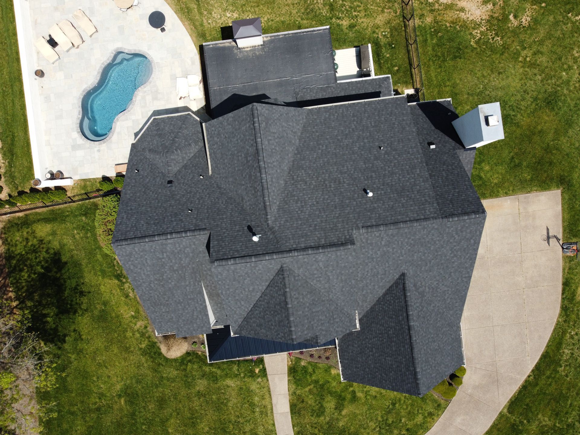 An aerial view of a large house with a pool in the backyard.