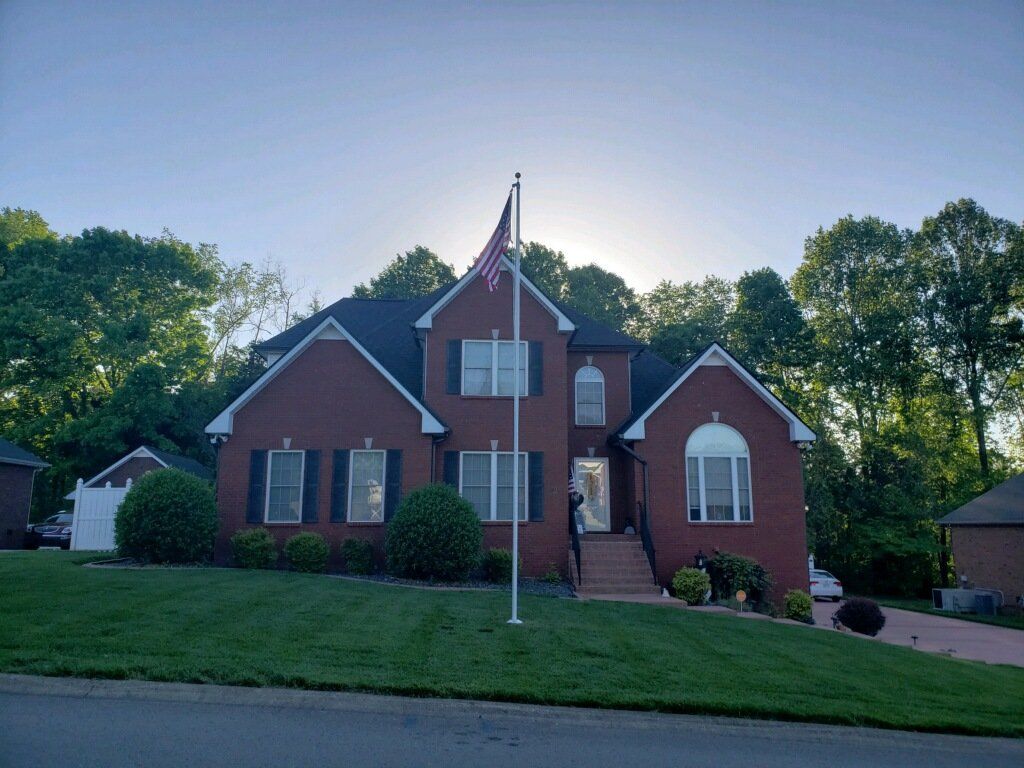 A large brick house with a flag pole in front of it