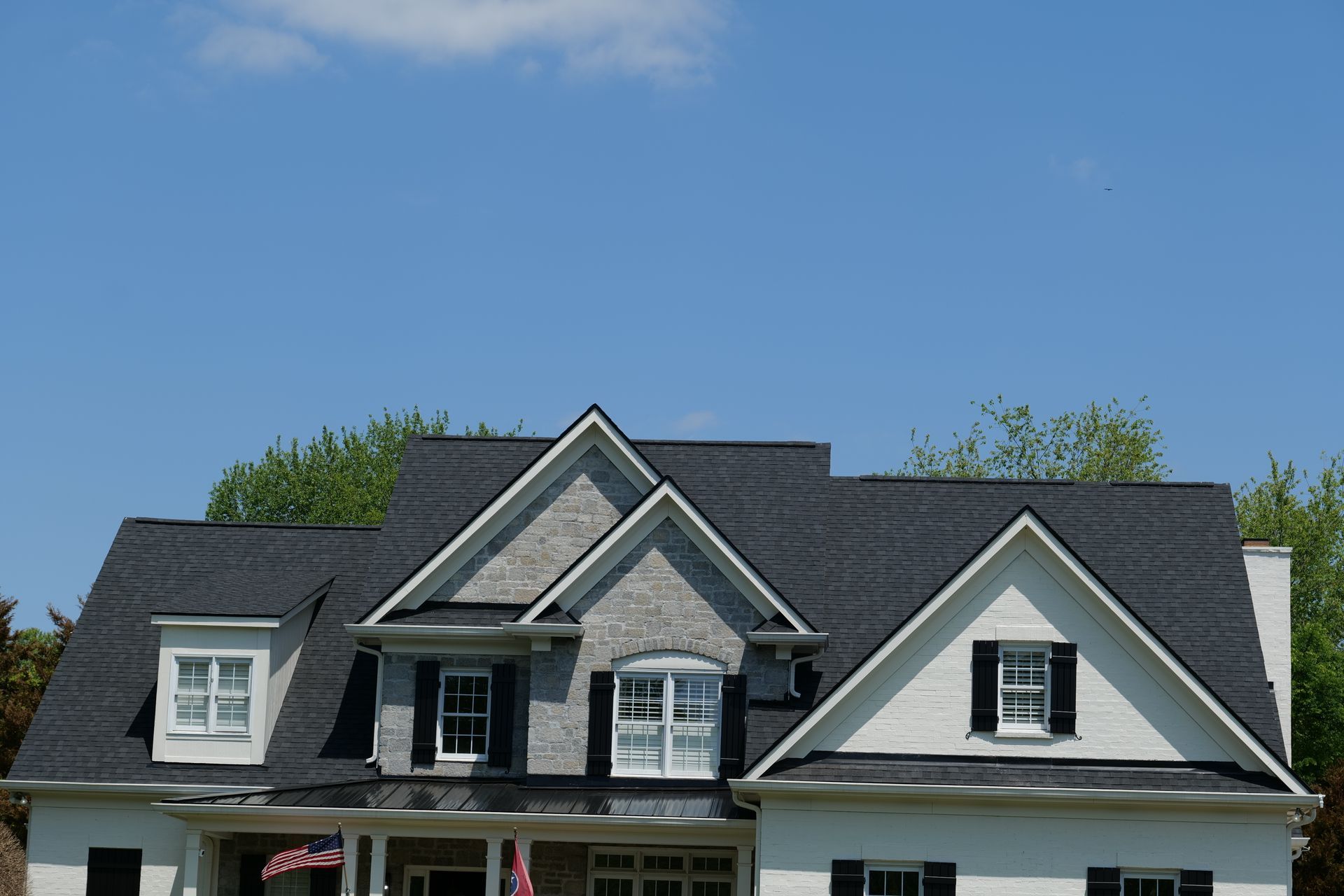A white house with a black roof and black shutters