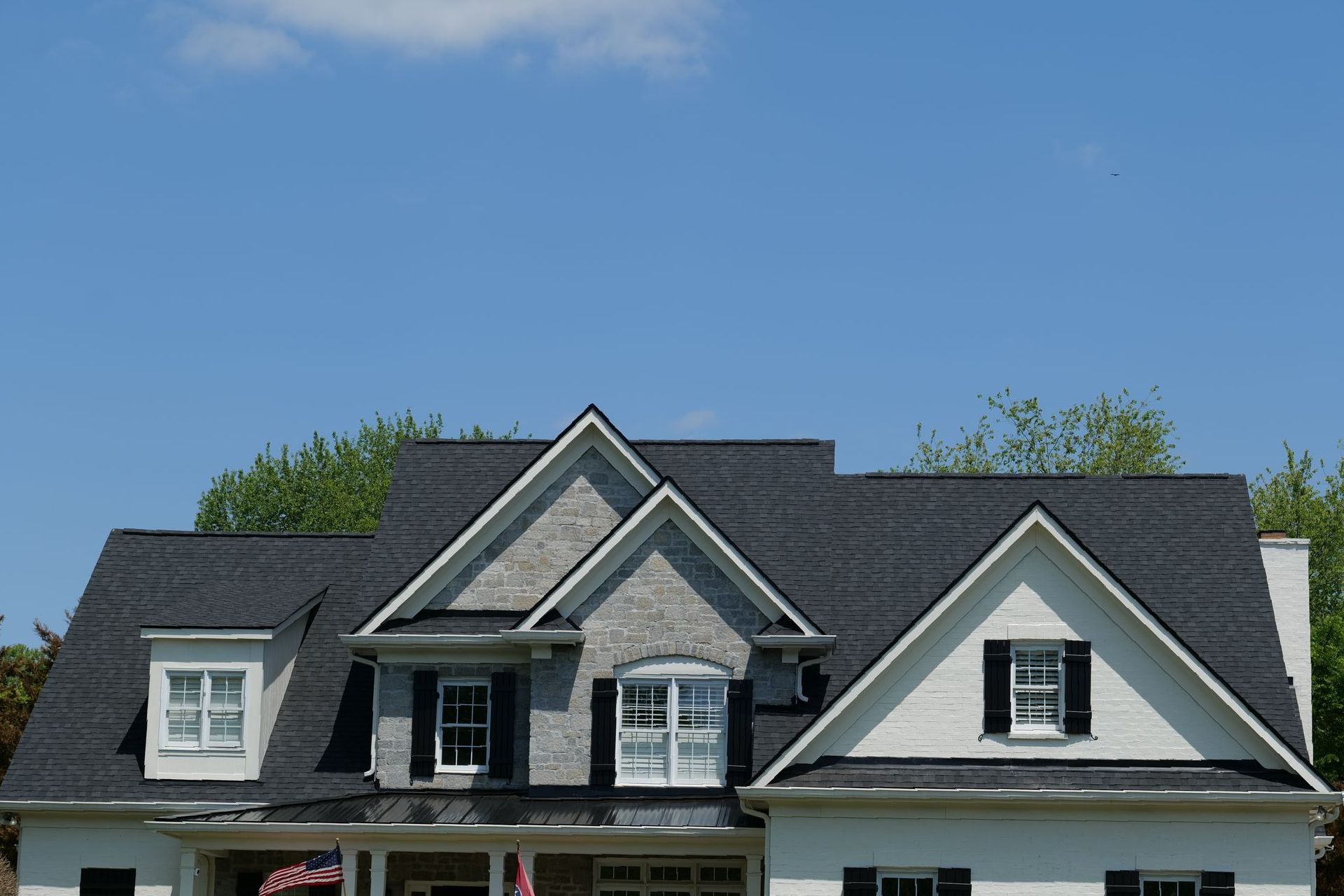 A white house with a black roof and black shutters
